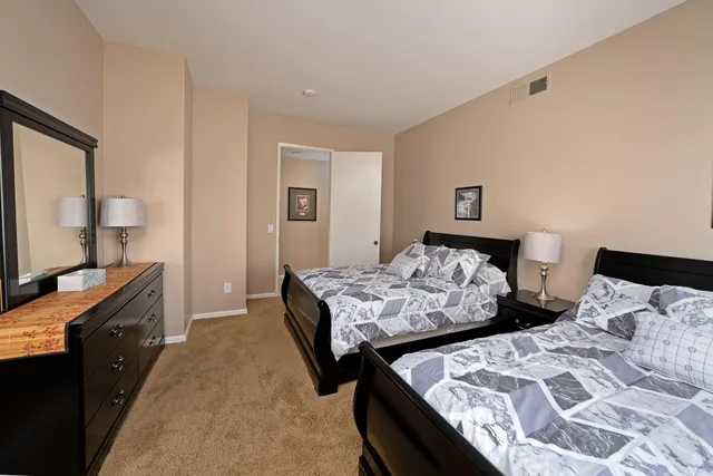 a bedroom with two beds and a dresser