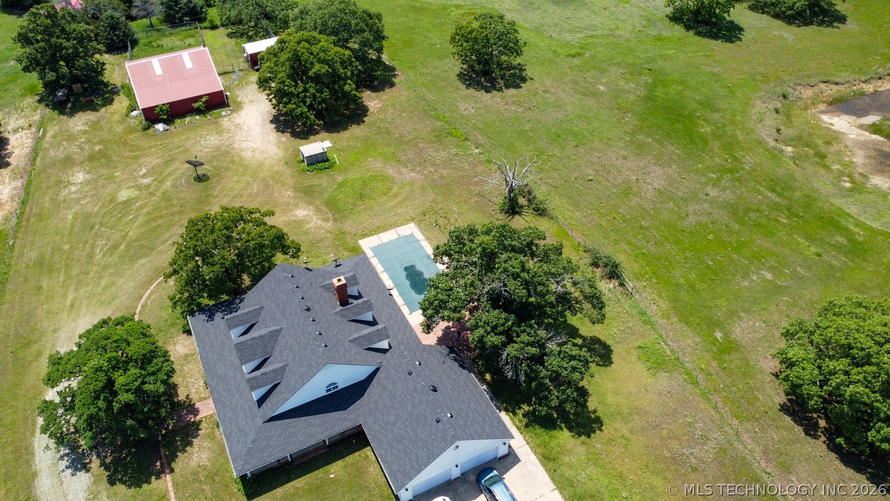 13248 North 3540th Road Maud, OK 74854 - Photo 31 of 98 Expansive property featuring a residence with a dark shingle roof, a rectangular swimming pool, and multiple mature trees