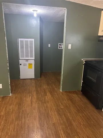 an empty room with wooden floor and mirror