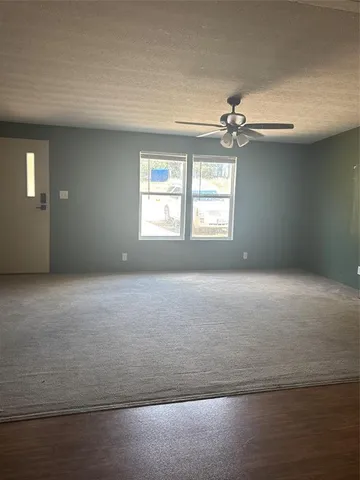 en empty room with windows and ceiling fan