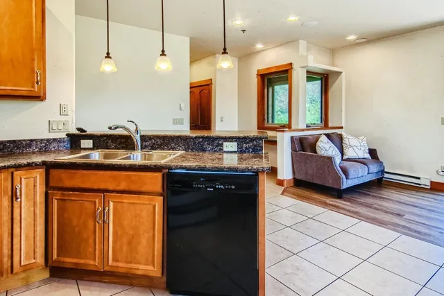 a kitchen with granite countertop a sink and a wooden cabinets
