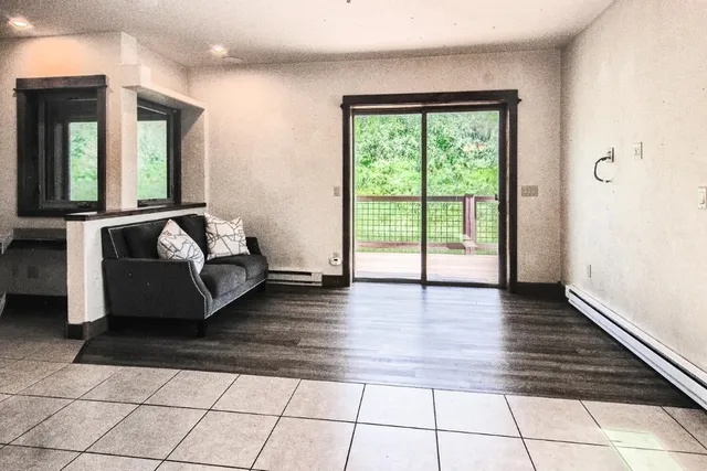a spacious bedroom with a bed and wooden floor