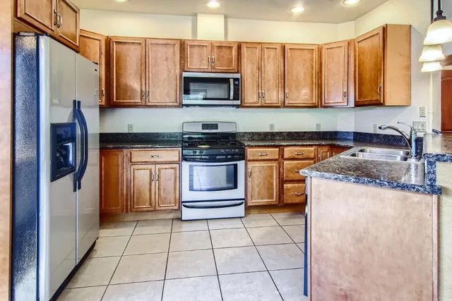 a kitchen with stainless steel appliances granite countertop a stove a sink and a microwave