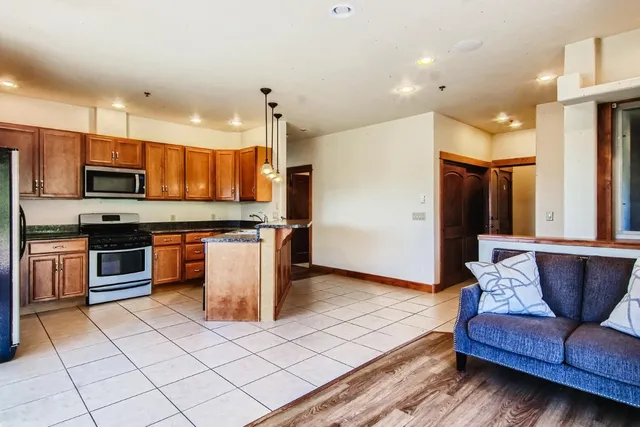 a kitchen with stainless steel appliances granite countertop a refrigerator a stove a sink and a microwave