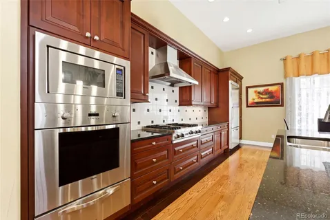 a large kitchen with stainless steel appliances granite countertop a stove and a refrigerator