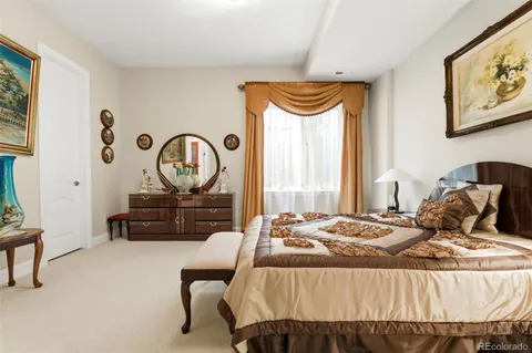 a bedroom with a bed and a mirror on the dresser