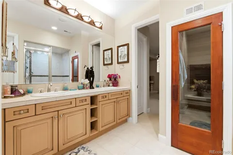 a spacious en suite bathroom with double sink and a mirror