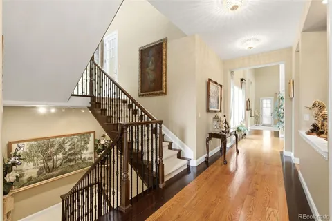 a view of a hallway with wooden floor and stairs
