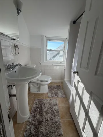 a bathroom with a sink toilet and a mirror
