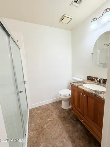 a bathroom with a granite countertop sink toilet and shower