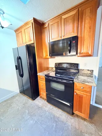 a kitchen with stainless steel appliances granite countertop a refrigerator stove and sink