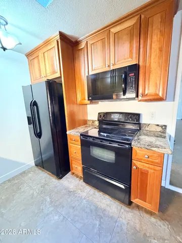 a kitchen with stainless steel appliances granite countertop a refrigerator stove and sink