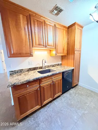 a kitchen with granite countertop cabinets stainless steel appliances a sink and a window