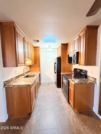 a kitchen with stainless steel appliances granite countertop a stove top oven a refrigerator a sink and dishwasher