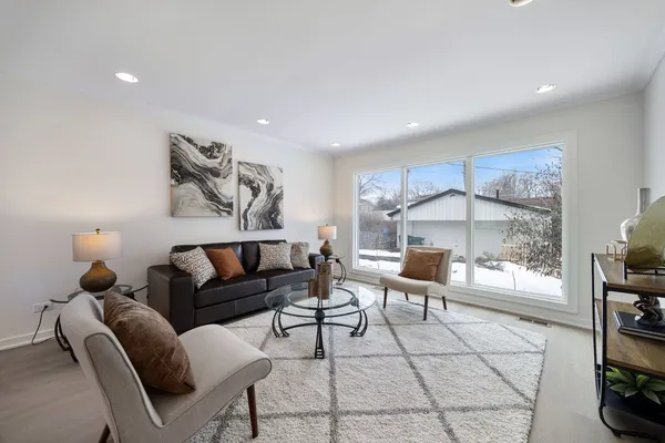 a living room with furniture a flat screen tv and a window