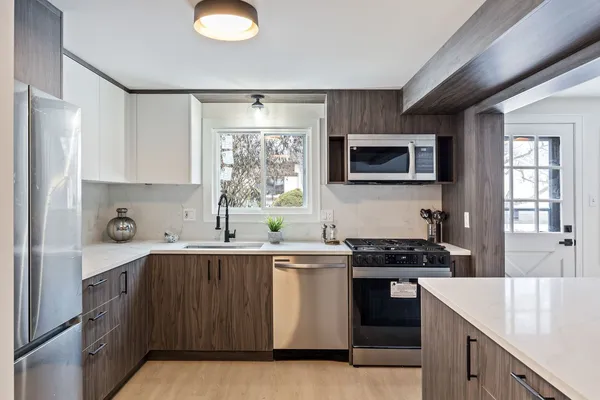 a kitchen with stainless steel appliances a stove sink microwave and cabinets