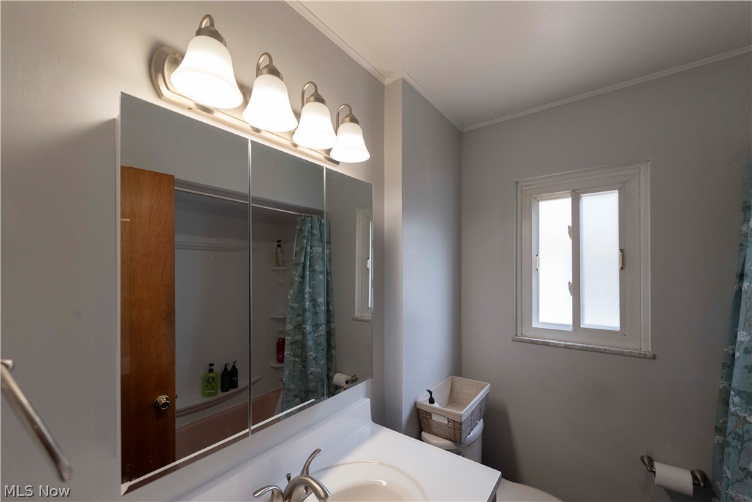 400 Baldwin Road Akron, OH 44312 - Photo 16 of 43 Main floor full bathroom vanity with a tri-fold mirrored medicine cabinet, a four-light fixture, and a single-basin sink