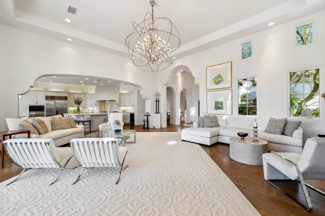 a view of a dining room with furniture a chandelier and a window