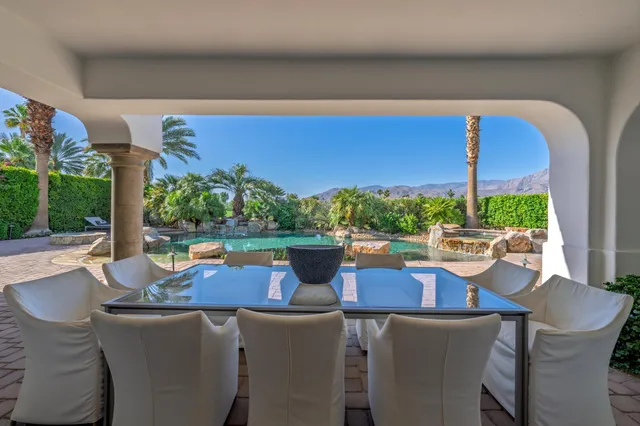 a view of a chairs and table in patio with a lake view