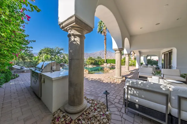a view of a lake with couches and table and chairs under an umbrella