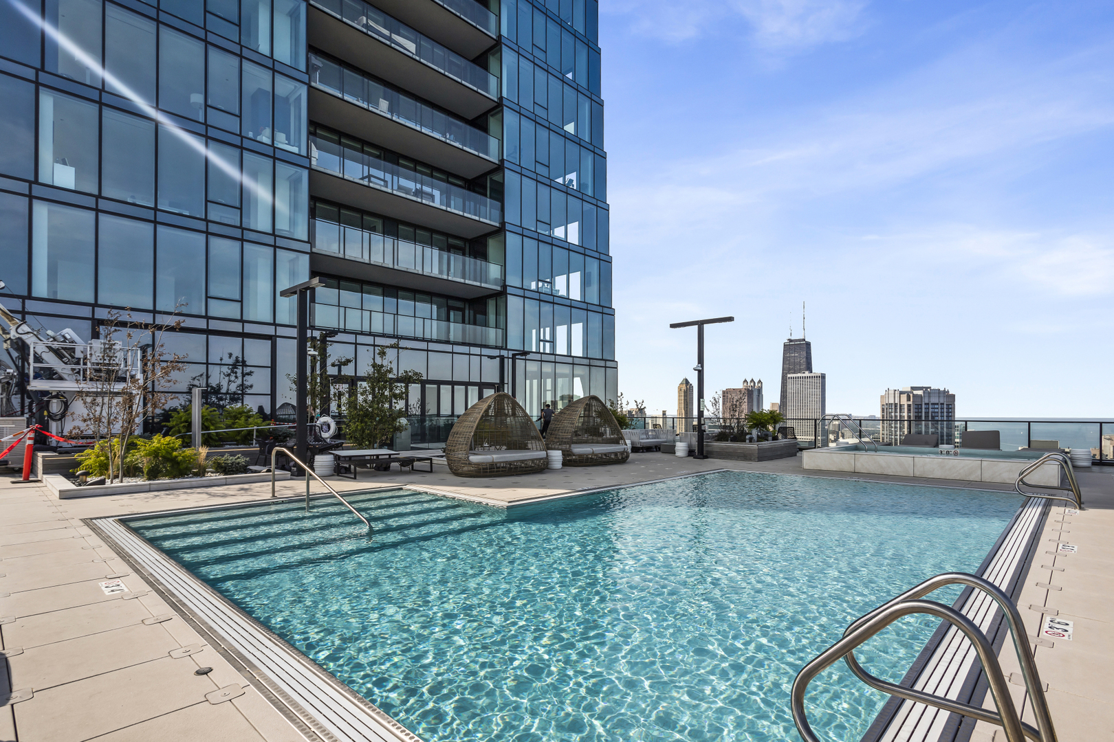 363 East Wacker Drive, Unit 2503 Chicago, IL 60601 - Photo 33 of 52 a view of a swimming pool with lawn chairs and a couch