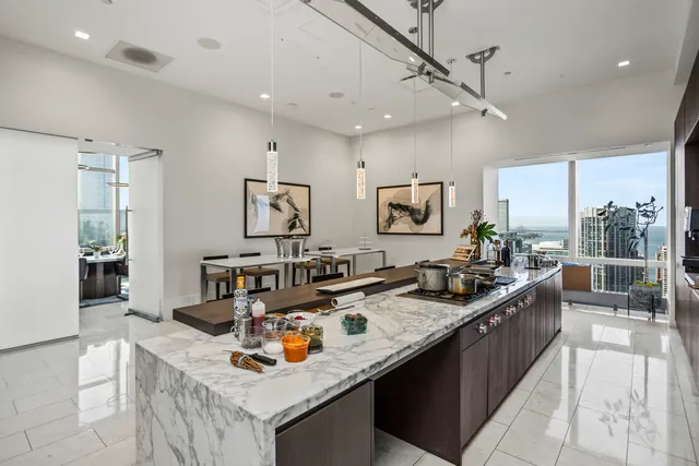a large white kitchen with a large window and stainless steel appliances
