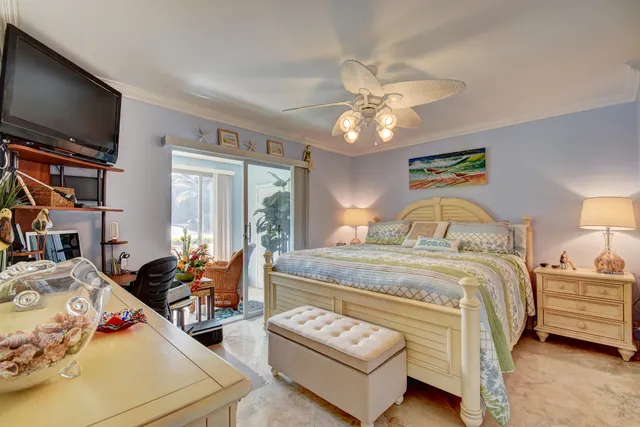 a bedroom with a bed and a flat tv screen on dresser