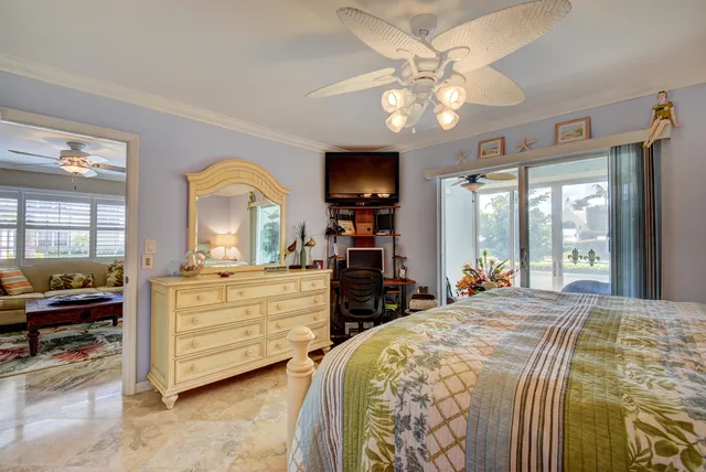 a bedroom with a bed a flat screen tv and a dresser