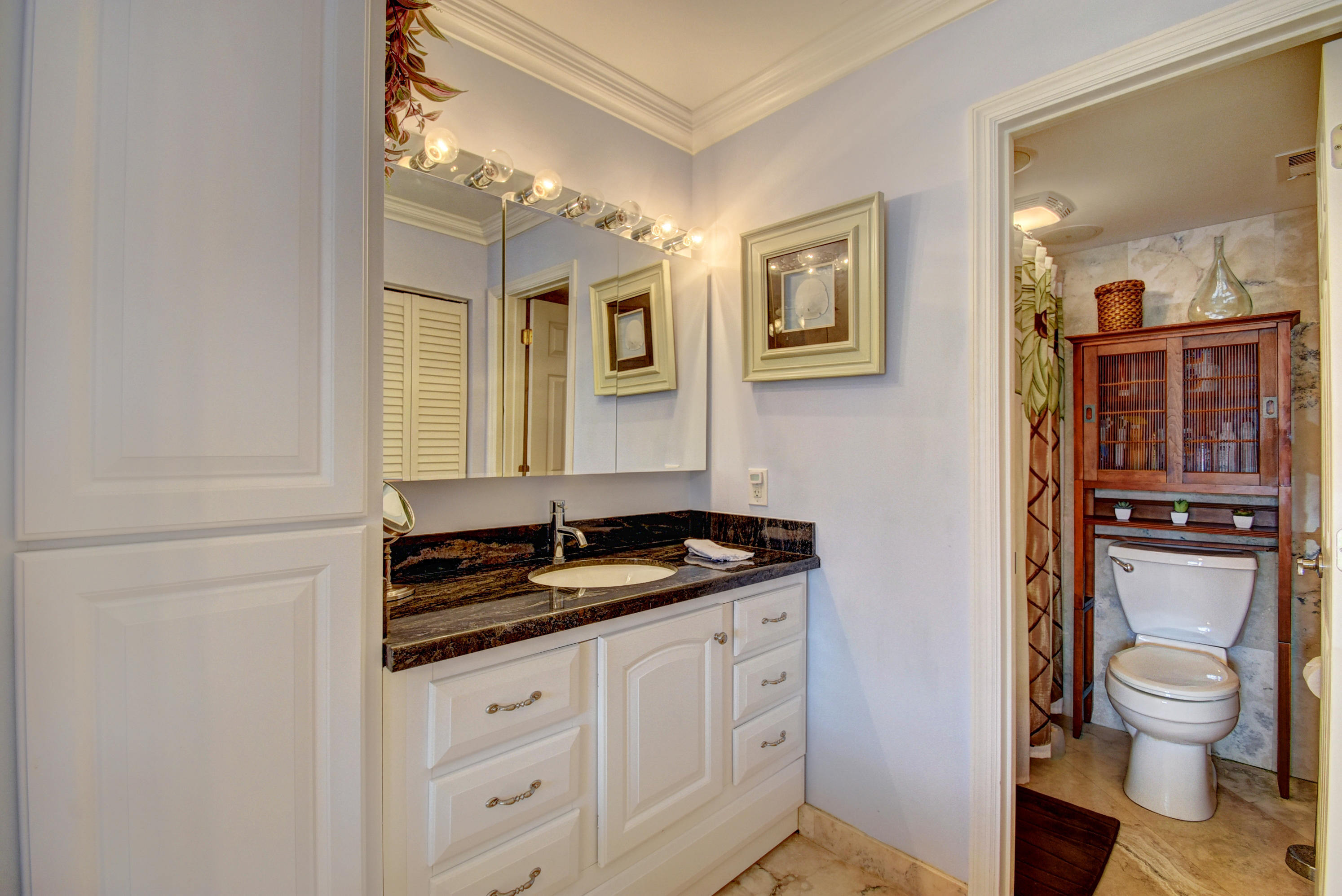 1700 South Ocean Boulevard, Unit 7 Delray Beach, FL 33483 - Photo 15 of 37 a bathroom with a granite countertop toilet sink and mirror