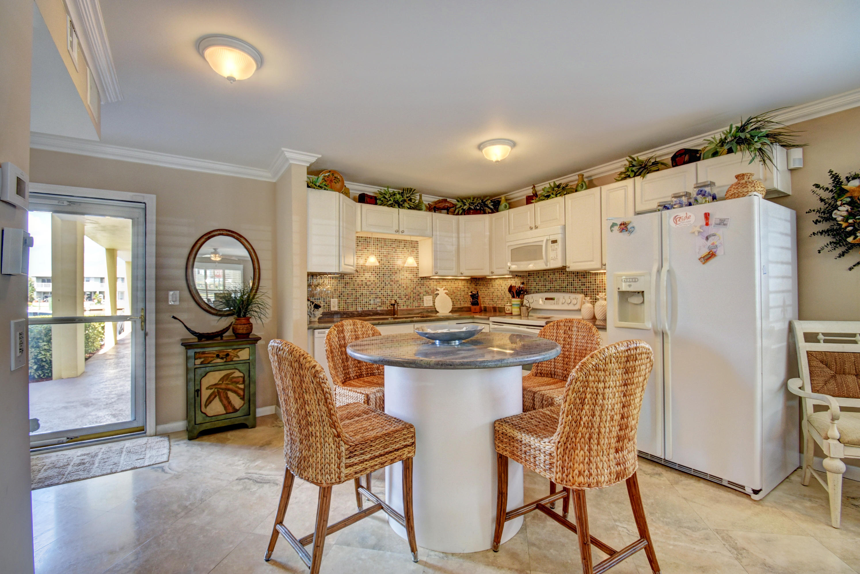 1700 South Ocean Boulevard, Unit 7 Delray Beach, FL 33483 - Photo 4 of 37 a kitchen with granite countertop a refrigerator a stove a dining table and chairs