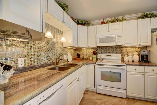 a kitchen with granite countertop white cabinets and white appliances