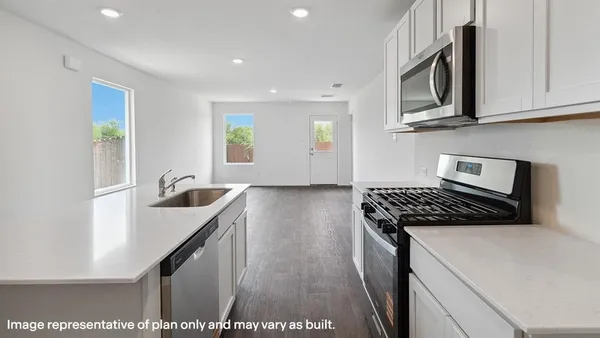 a kitchen with stainless steel appliances granite countertop a stove a sink and a microwave