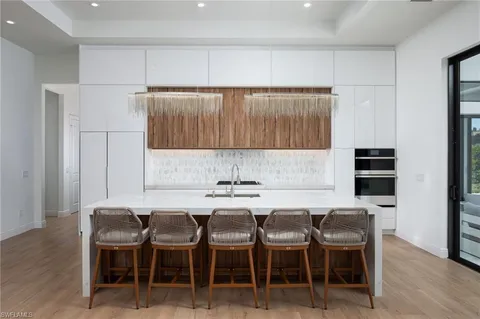 a kitchen with a dining table chairs and a refrigerator