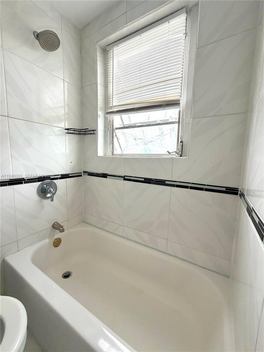 967 Southwest 5th Street, Unit 18 Miami, FL 33130 - Photo 12 of 12 a bathroom with a bathtub and a window