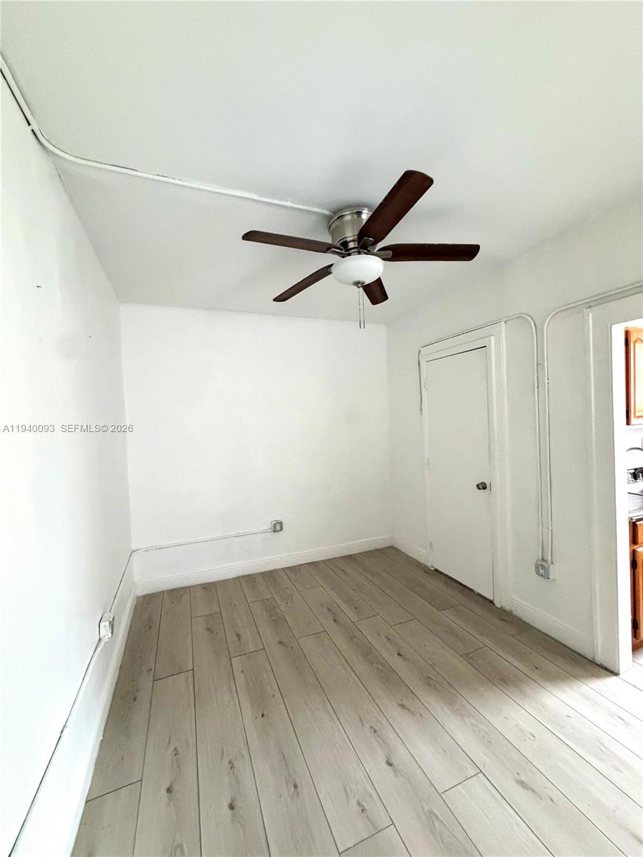 967 Southwest 5th Street, Unit 18 Miami, FL 33130 - Photo 2 of 12 a view of a room with wooden floor and white walls