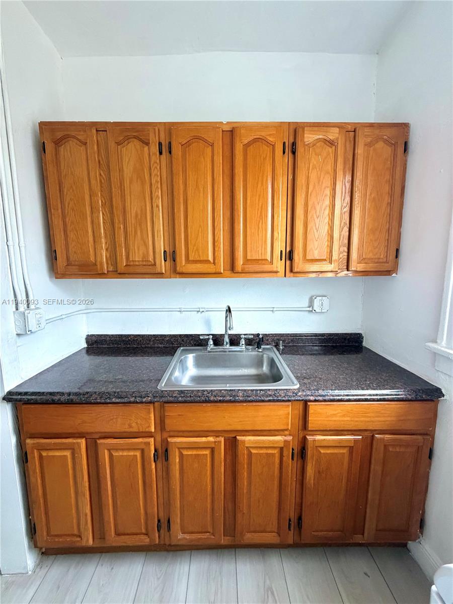 967 Southwest 5th Street, Unit 18 Miami, FL 33130 - Photo 4 of 12 a kitchen with granite countertop a sink a cabinets and a granite counter top