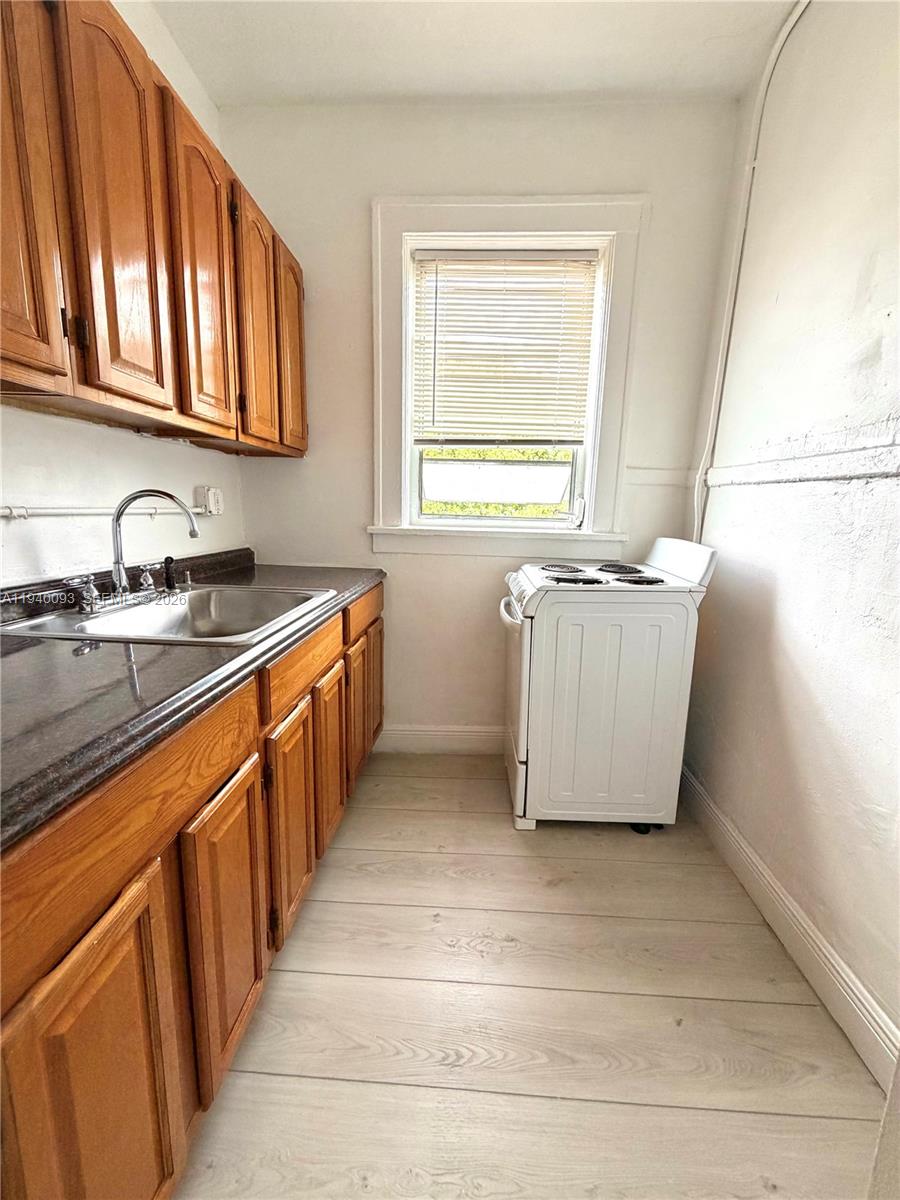 967 Southwest 5th Street, Unit 18 Miami, FL 33130 - Photo 5 of 12 a kitchen with stainless steel appliances granite countertop a sink stove and cabinets