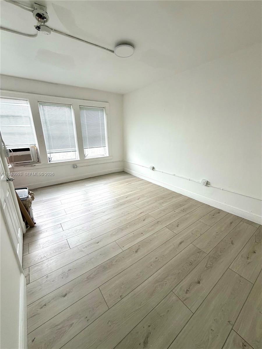 967 Southwest 5th Street, Unit 18 Miami, FL 33130 - Photo 9 of 12 an empty room with wooden floor and window