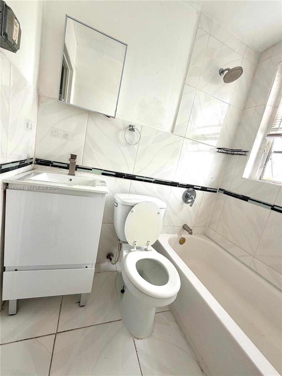 967 Southwest 5th Street, Unit 18 Miami, FL 33130 - Photo 10 of 12 a bathroom with a toilet sink and mirror