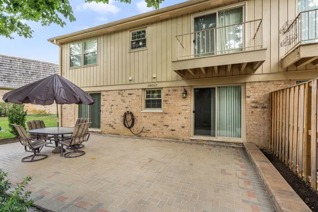 a view of patio with a table and chairs under an umbrella