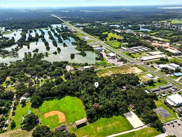 an aerial view of residential houses with outdoor space and trees