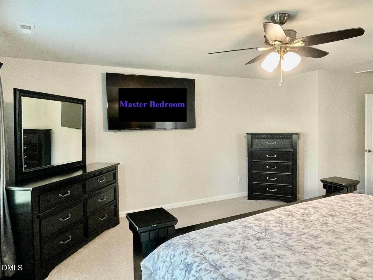 1807 Wrenn Road Durham, NC 27703 - Photo 41 of 43 a bedroom with a bed and a flat tv screen on dresser