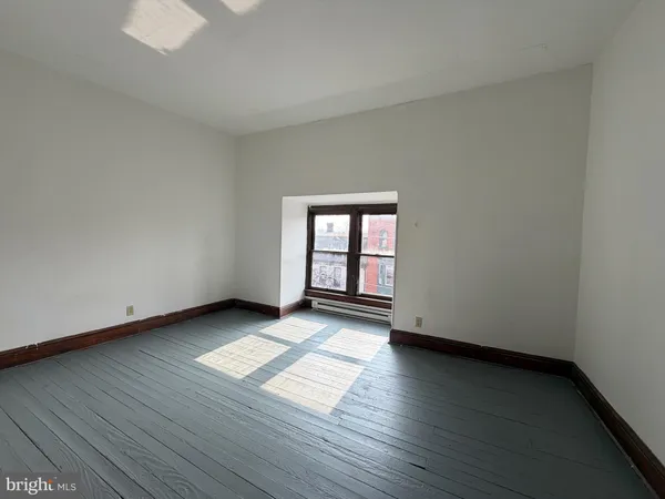 a view of a room with wooden floor and window