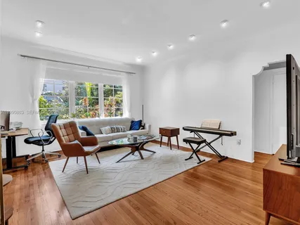 a living room with furniture and a wooden floor