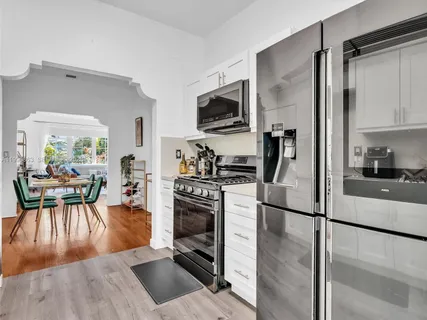 a kitchen with kitchen island a counter top space a sink stainless steel appliances and cabinets