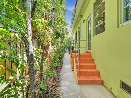a view of a backyard with plants and furniture