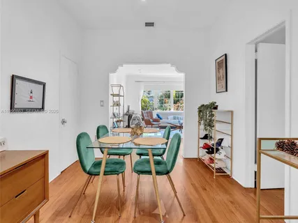 a view of a dining room with furniture a chandelier and wooden floor
