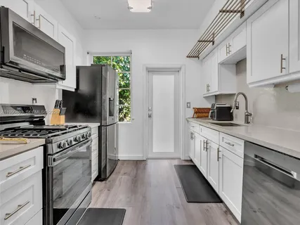 a kitchen with stainless steel appliances a stove microwave and a refrigerator