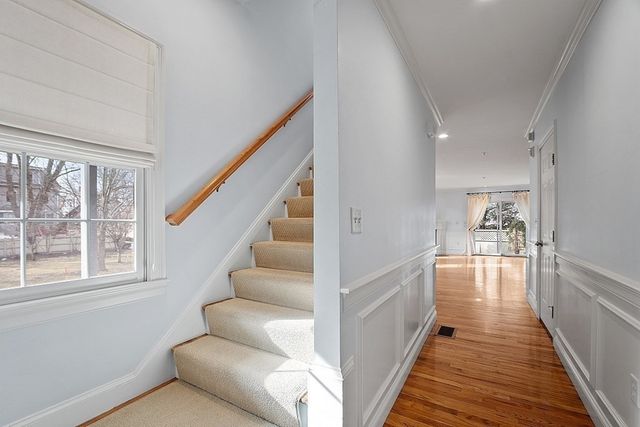 a view of a hallway with wooden floor and staircase