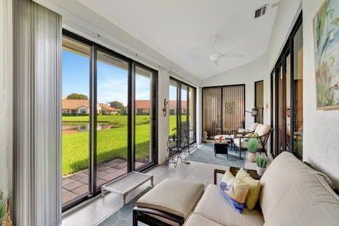 a living room with furniture and floor to ceiling windows